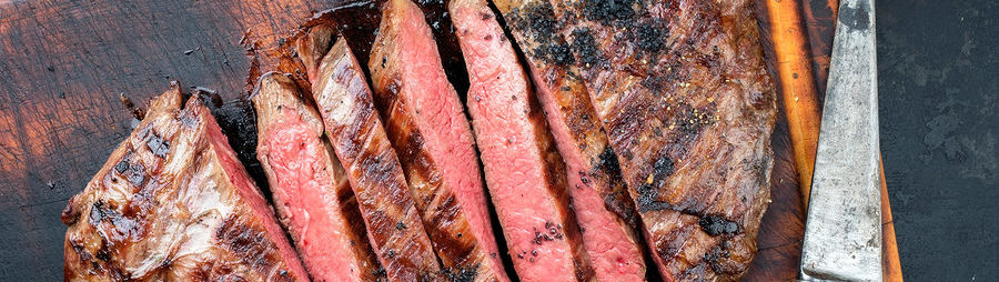 Sliced medium-rare steak on a wooden cutting board