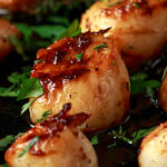 Scallops seared in garlic and parsley butter served in cast iron skillet