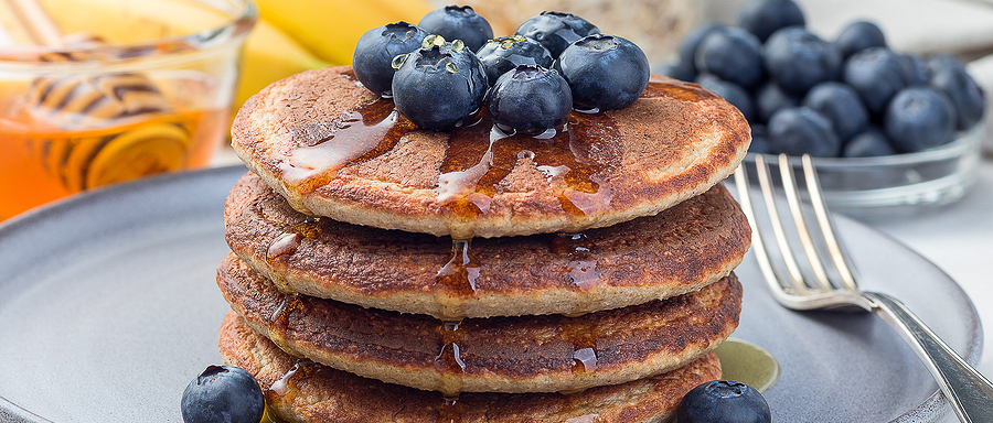 heart healthy stack of pancakes with blueberries and syrup