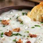 a bowl of clam chowder with croutons on top