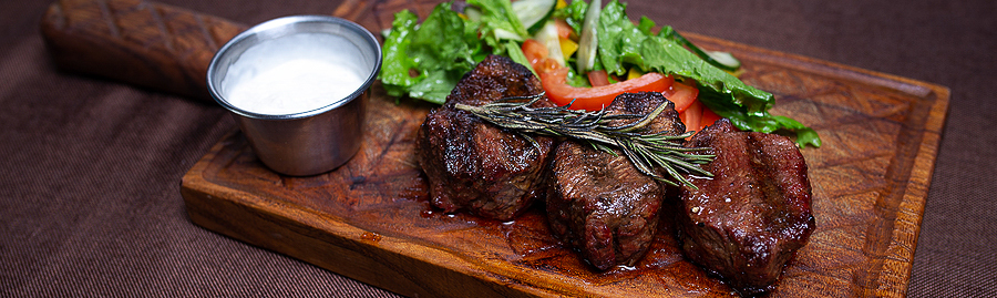 pan seared steak on board with salad