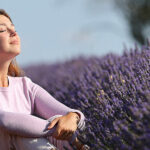 a woman sitting in a field of lavender